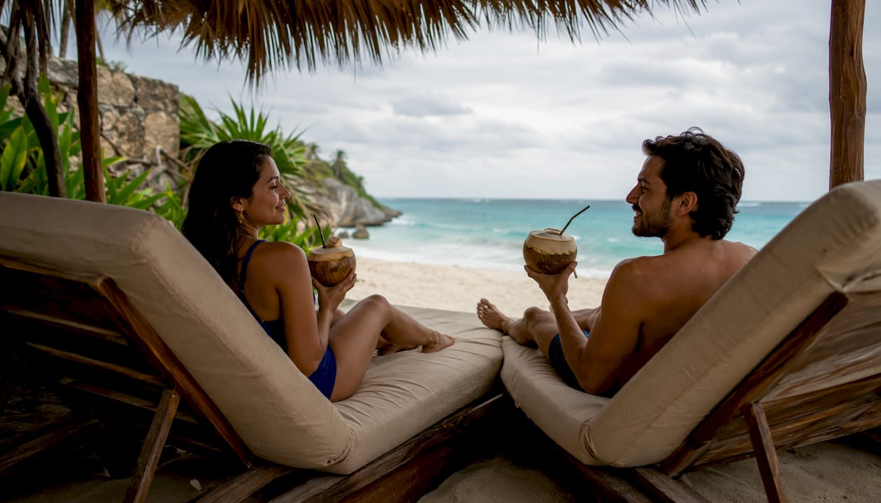 Couple relaxing on hammocks at tropical beach