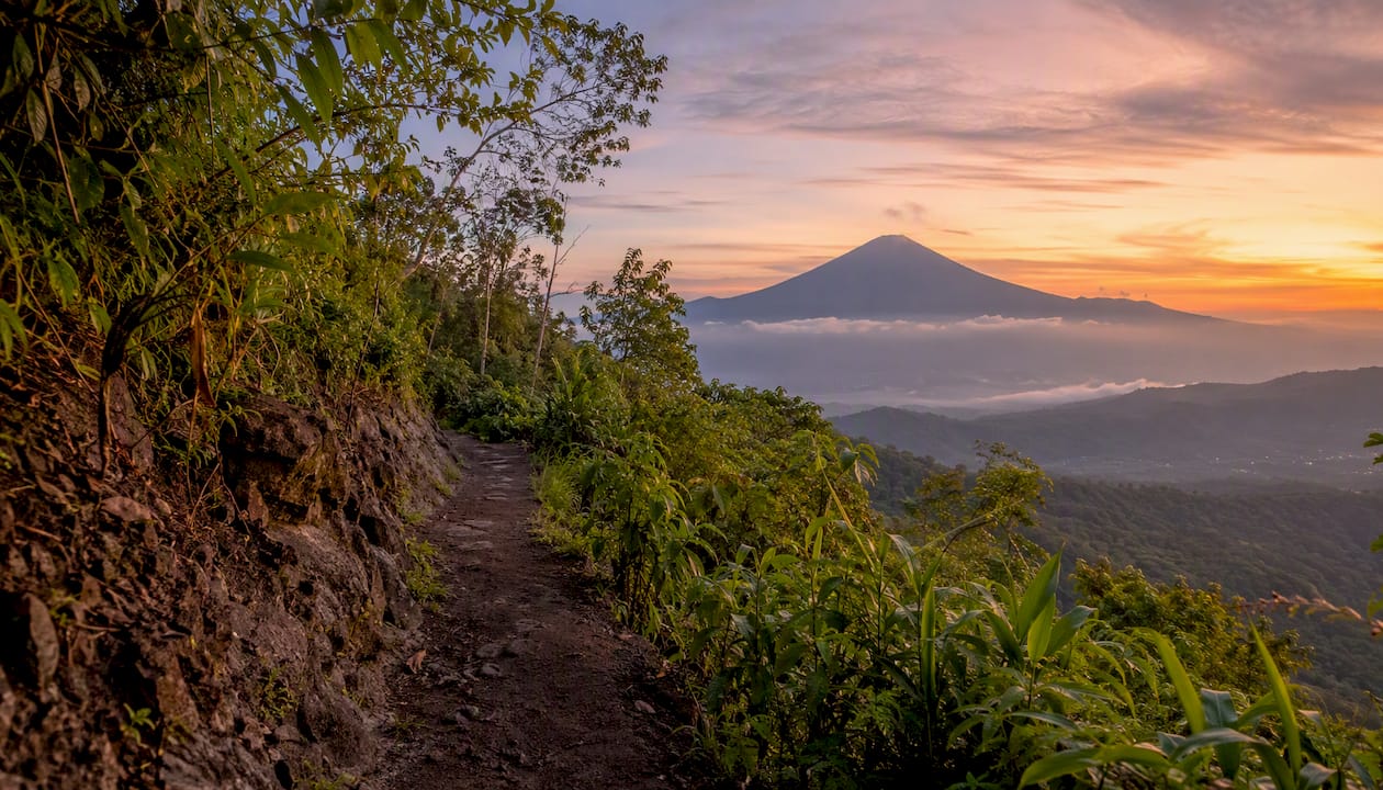 Sunrise volcano hike trail with jungle surroundings