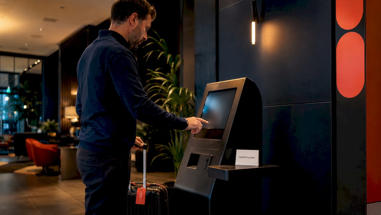 Ein Mann checkt am Selbstbedienungsterminal ein.
