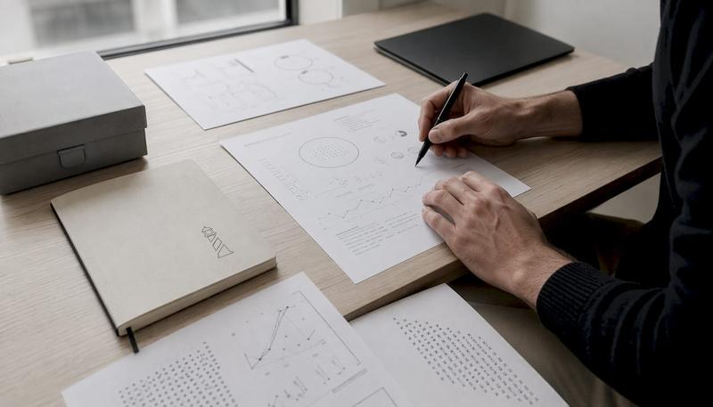 Des mains déposent un stylo sur un rapport SEO fraîchement imprimé.