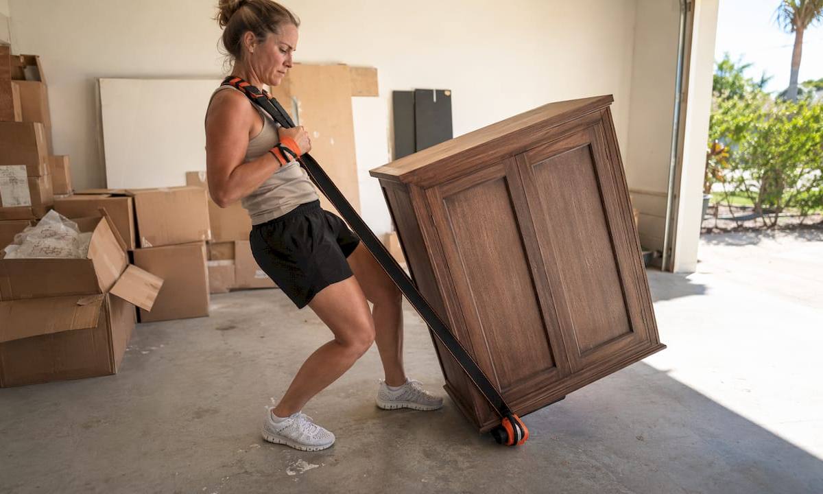 Hands using shoulder dolly and moving blankets