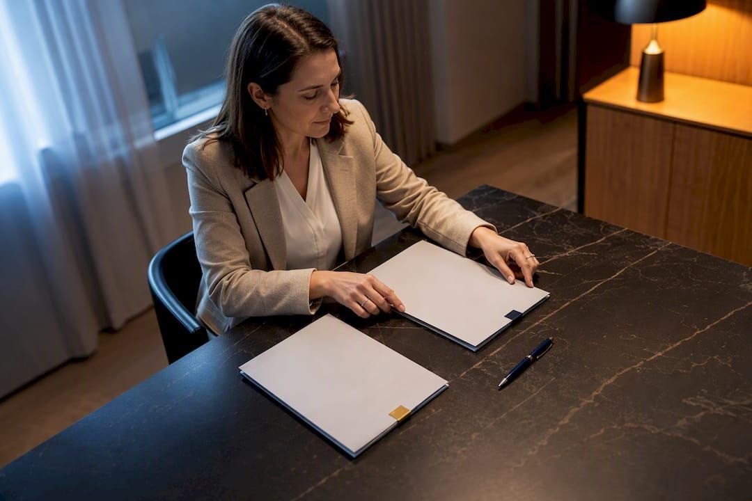 Frau mit zwei Dokumentenmappen an einem Besprechungstisch