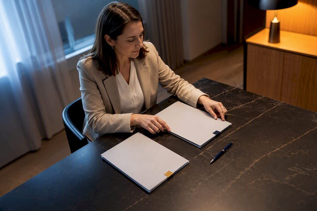 Frau mit zwei Dokumentenmappen an einem Besprechungstisch