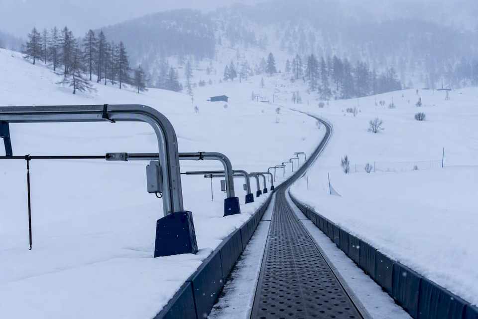 Child skiing on a magic carpet conveyor lift