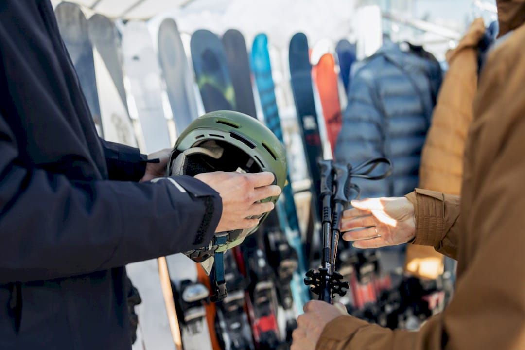 Hände vergleichen Skischuhe in einem Verleihgeschäft