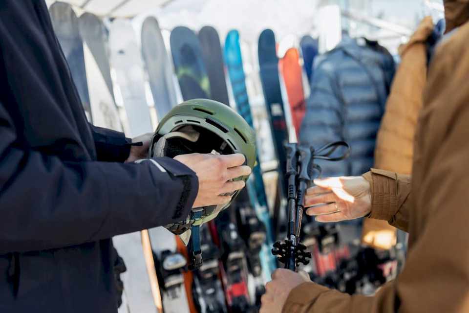 Hände vergleichen Skischuhe in einem Verleihgeschäft