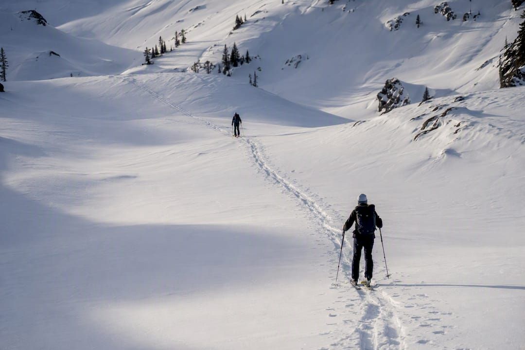 Two ski tourers sharing a skin track responsibly
