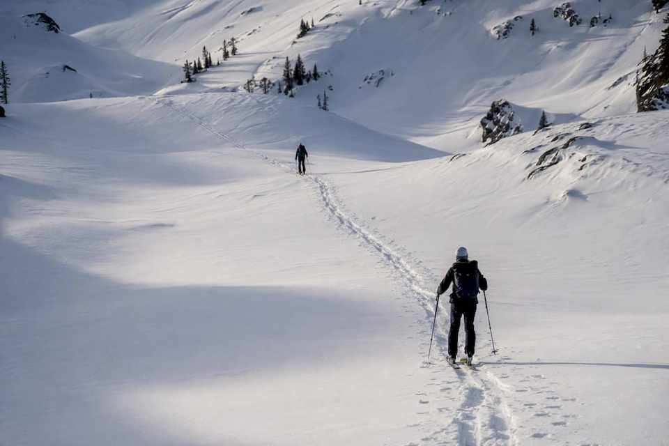 Two ski tourers sharing a skin track responsibly