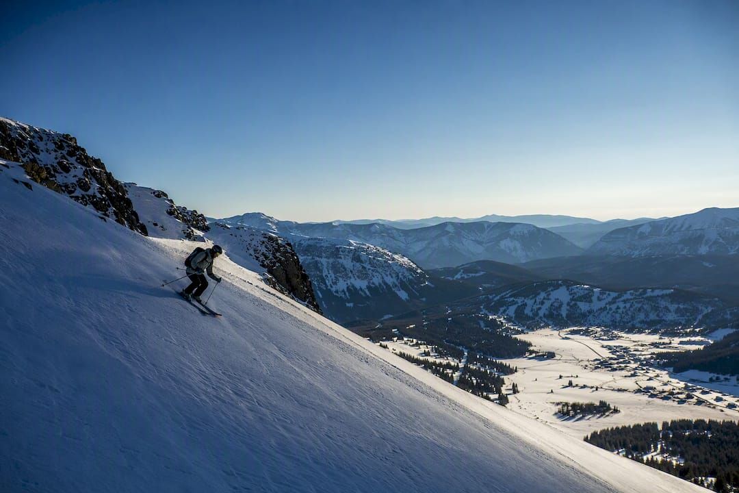 Skier crossing contrasting alpine snowfields