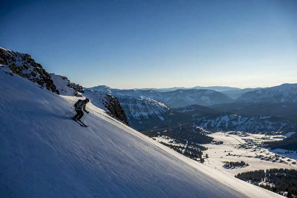 Skier crossing contrasting alpine snowfields