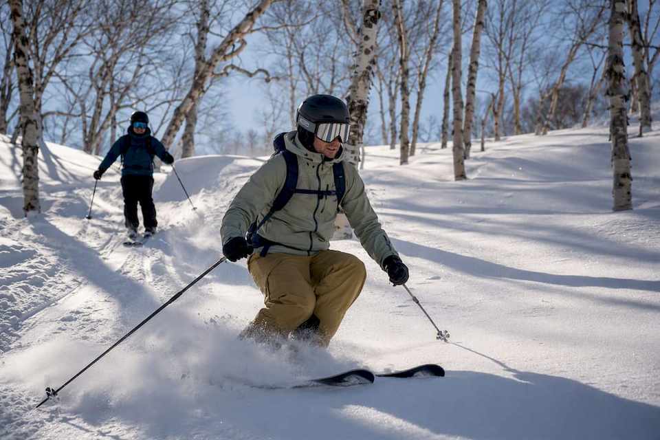Intermediate skier entering guided powder terrain