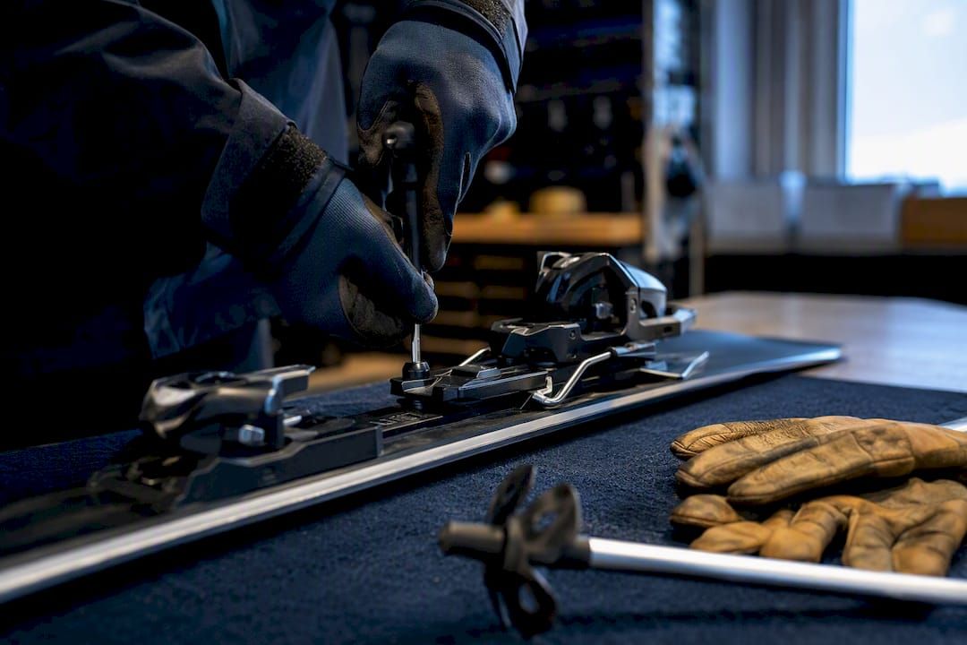 Technician repairing ski binding at bench